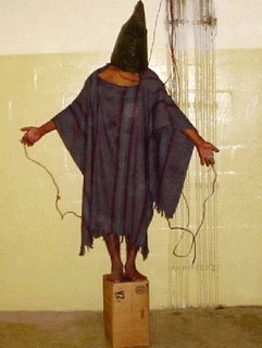 Foto que correu o mundo, de autoria desconhecida, provavelmente captada por carcereiros ou soldados americanos, de tortura na prisão de Abu Ghraib, no Iraque ocupado, em 2003 ou 2004.