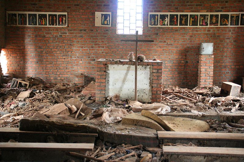 Altar da igreja de Ntrama, hoje um memorial do genocídio. <em>“De Kibuye, no oeste, a Kibungo, no leste, as pessoas se reuniam, aos milhares, em busca de refúgio nas igrejas, nos hospitais, nas escolas. E quando eles foram encontrados, os velhos e os doentes, mulheres e crianças, eles foram mortos - mortos porque sua carteira de identidade dizia que eram tutsis ou porque eles tinham um pai tutsi, ou porque alguém achava que eles pareciam um tutsi, ou mortos, como milhares de hutus, porque protegiam os tutsis ou não toleravam uma política que tentava eliminar as pessoas que, no dia anterior e durante anos antes, tinham sido seus amigos e vizinhos.Discurso de Bill Clinton em 25 de março de 1998