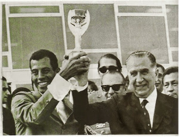 Emílio Médici ergue a Taça Jules Rimet, com Carlos Alberto, capitão da seleção brasileira tricampeã no México, em Brasília, em junho de 1970