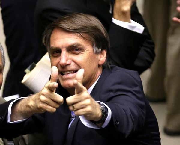 Com seu gesto característico, o presidente Jair Bolsonaro indica que o governo enxerga o Estado como uma milícia